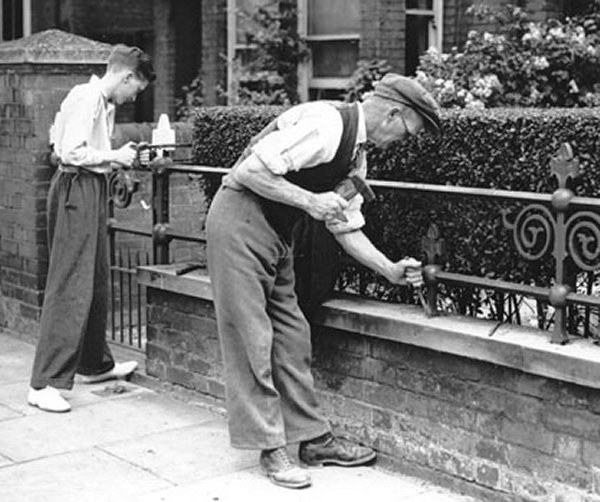 Workmen removing decorative iron railings